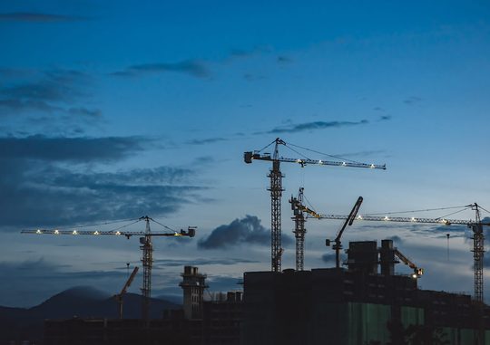Several cranes above building.