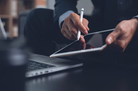 Businessman with digital tablet and laptop. Photo.