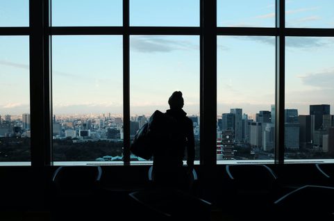 Silhouette of a man looking at a city view.