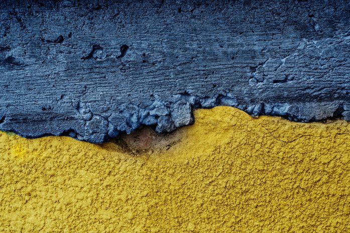 Ukraine flag painted on textured wall.